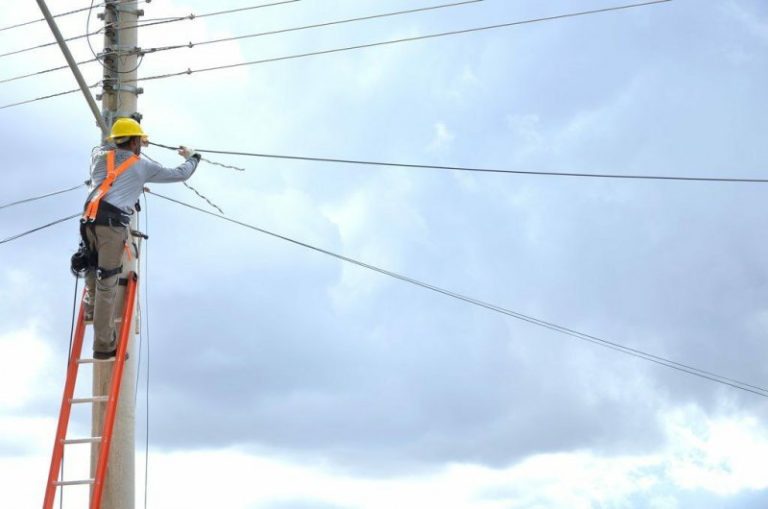 profissional no poste fazendo instalação de rede óptica